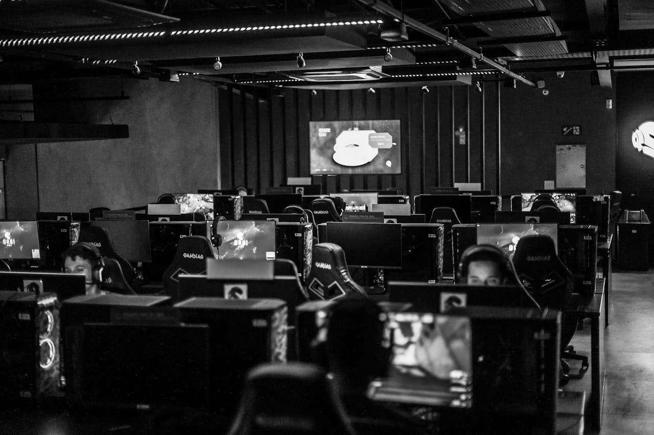 about-04 Black and white view of an active esports gaming studio with players immersed in video games.