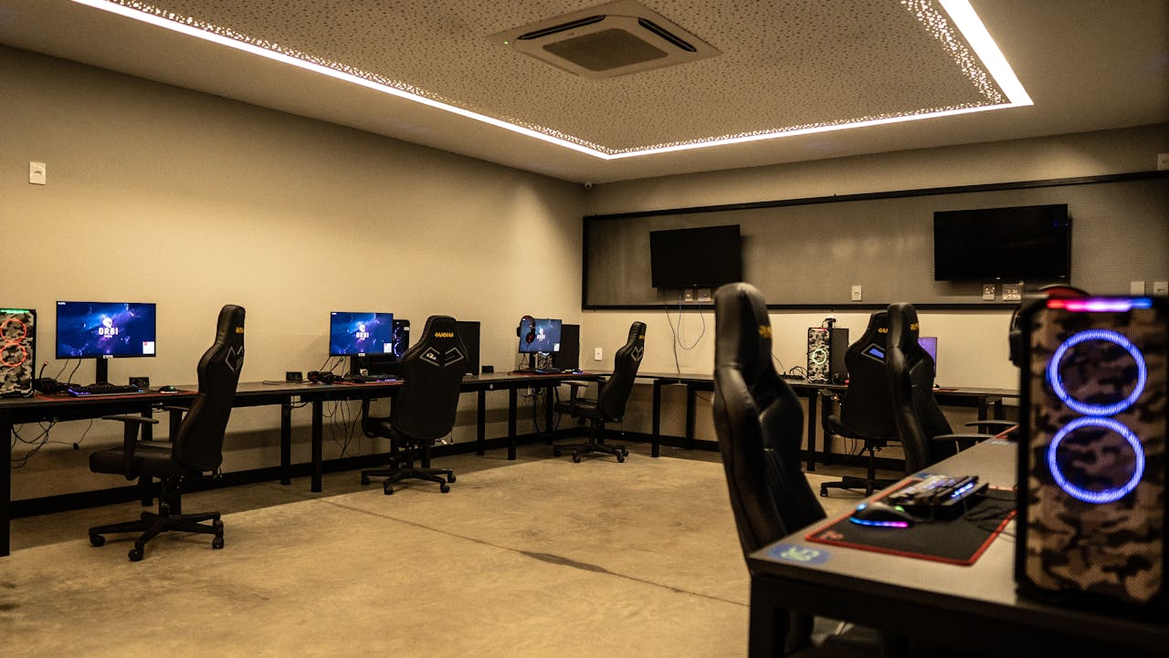 about-02 A modern gaming room featuring high-performance PCs, gaming chairs, and sleek design.